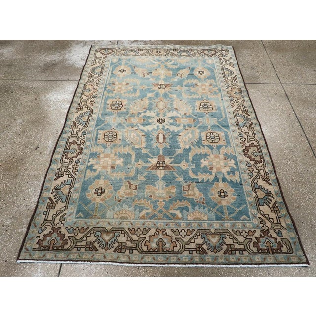This mid-20th-century Persian Malayer accent rug presents a balanced floral composition across a soft blue field. Stylized...
