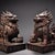 This is a matching pair of cast bronze guardian lion (Pixiu) figurines, featuring a gilded finish with a dark, aged...