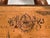 A long, rectangular engraved copper wall plate mounted on a dark wood backing depicting a panoramic bird's-eye view of...