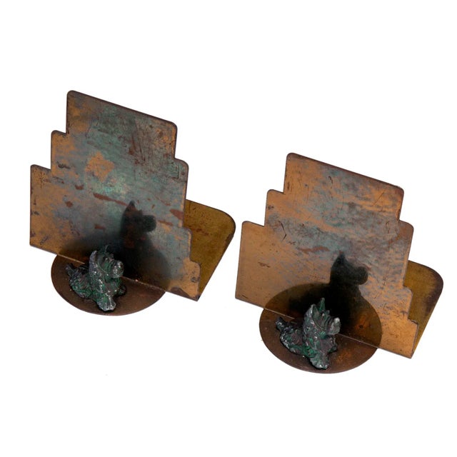 Art deco bookends with deco gradual step background and little scotty statue sitting on the base.