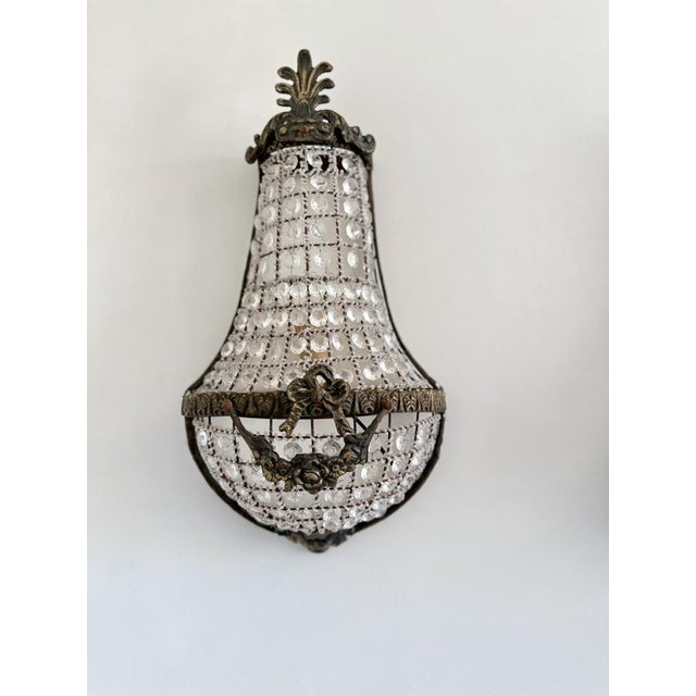 Near pair of French Empire Style wall sconces with Louis XVI Revival detailing, dating to the early 20th century....