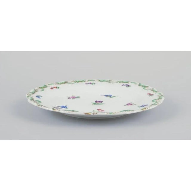 Meissen, Germany. A set of four antique porcelain plates. Hand-decorated with polychrome floral motifs, gold-decorated...