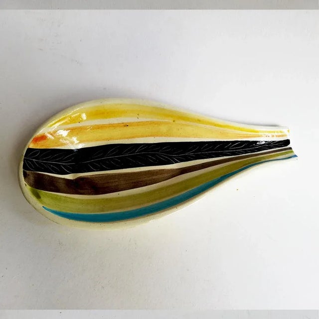 This centrepiece has ceramic decoration in yellow, green and black stripes, signed Tasca.