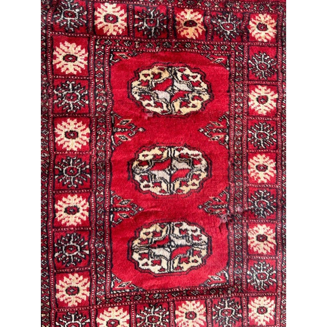 Vintage Bokhara design Pakistani rug with a red field colour and white, gray and black, entirely hand knotted with wool on...