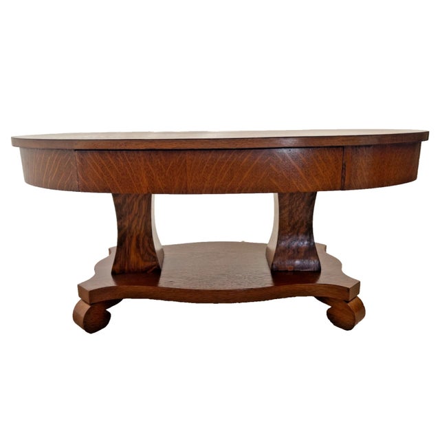 Offered for sale is a stunning antique American oak table featuring exceptional tiger oak wood grain, a spacious oval top,...