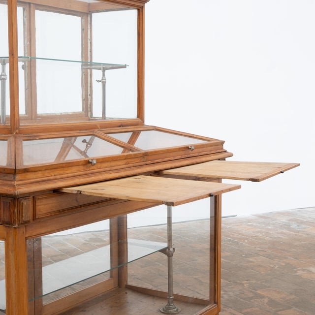 Antique fir display cabinet dating from the early 20th century. It consists of two sections. The lower section, largely...