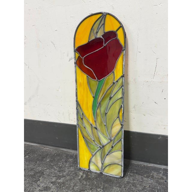 Design Plus Gallery presents a Red Tulip Stained Glass Panel by Gene LeLonde. The panel has a stylized red tulip rising...
