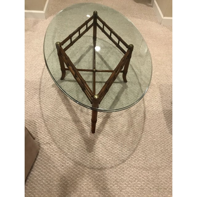 This oval Maitland Smith–style coffee table brings Palm Beach Regency flair to any room, pairing faux bamboo detailing...