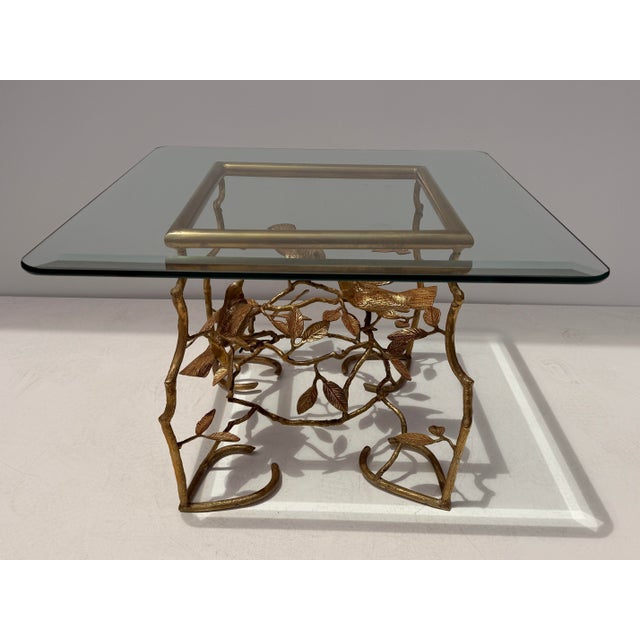 Small brass coffee / side table with birds perched on tree branches in the style of Diego Giacometti Glass top is 26”x26”