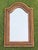 Vintage wall mirror featuring a distinctive serpentine-shaped crest and intricately woven rattan frame. The warm natural...
