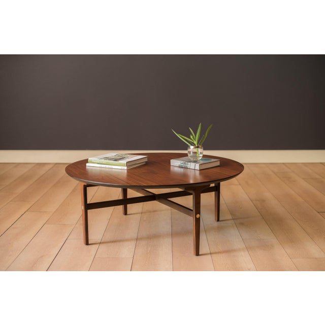 Vintage low profile round coffee table in walnut manufactured by Stanley Furniture Company, circa 1960's. This unique two-...