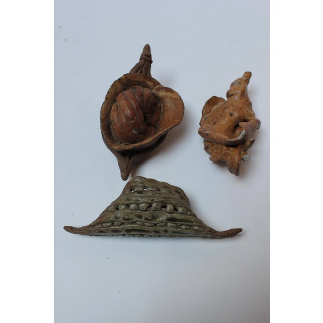 Three studio ceramic abstract sea / nature specimens in attractive earth tones depicting two shells and a heavily textured...