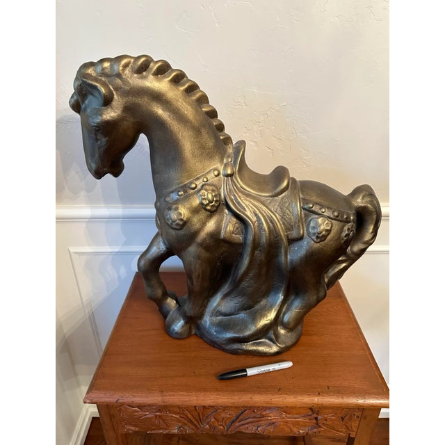 This large bronze-look plaster statue in the style of a Chinese Tang Dynasty horse makes a dramatic statement. The horse...