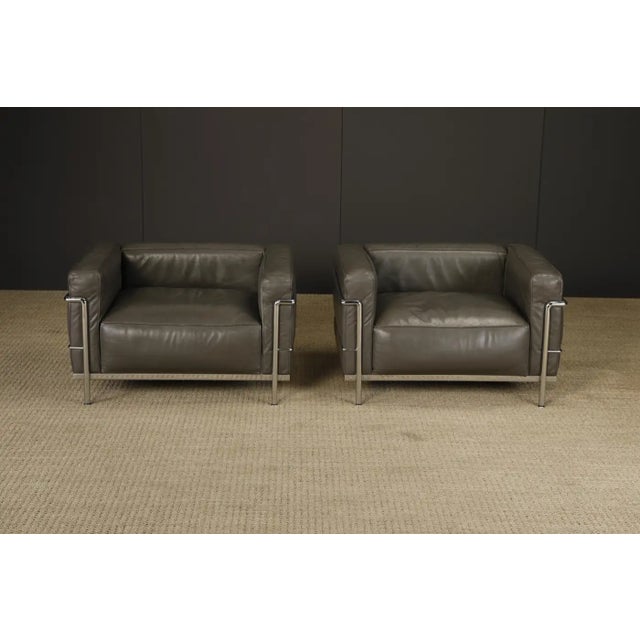 An incredible pair of early production year (ideal for collectors) 'LC3' club chairs in grey leather, by Le Corbusier,...