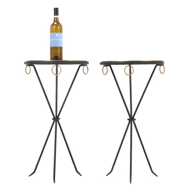 An elegant pair of iron drinks tables, each featuring bronze ring detailing encircling both the round tops and apron. The...