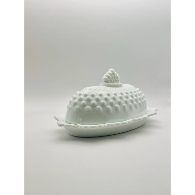 A beautiful mid 20th century scallop edged butter dish in a hobnail pattern done in milk glass.