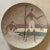 Large decorative ceramic platter portraying two male figures on a beach with a stylized net and a female figure in the...
