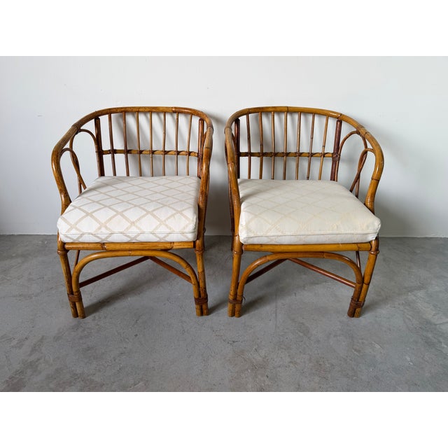 Beautiful pair of vintage coastal barrel lounge chairs featuring a handcrafted bamboo and rattan frame with elegant curved...