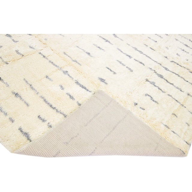 Beautiful Moroccan- Style handmade wool rug with an Ivory field. This Moroccan rug has gray accents in a gorgeous all-over...