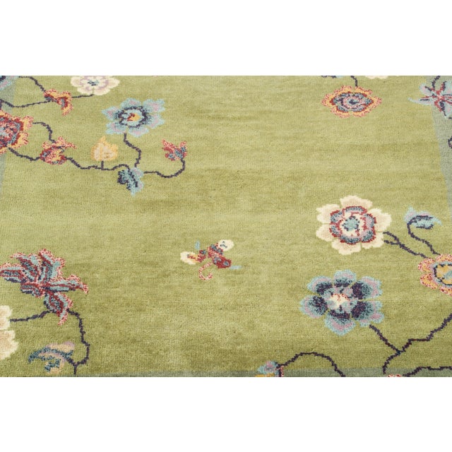 Hand-knotted in wool, this 3x3 contemporary Chinese Deco square rug showcases a warm olive-green field enclosed by a sage...