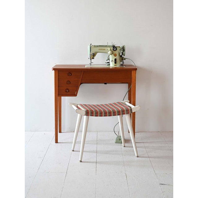 Teak work table with folding top and sewing machine included. There are also three drawers. An original vintage Swedish...