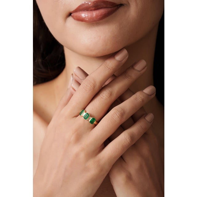 This three stone ring features a 0.6 carats natural octagon emeralds set in 14K yellow gold. Each emerald set in smooth...