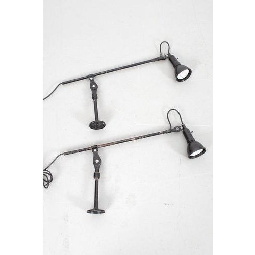 Set of 2 industrial lamps. The lamp has an adjustable wall mount. The shade can’t be adjusted. Both lamps have traces of...