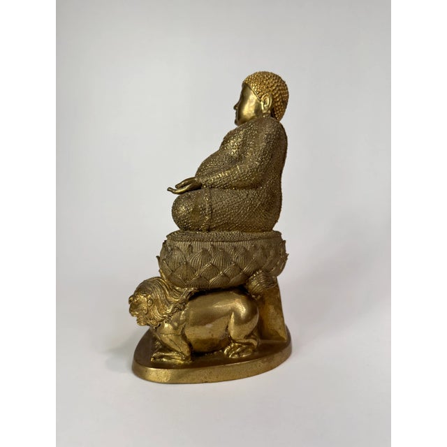 Bronze metal buddha. Depiction of buddha seated upon a large cushion and flanked by a pair of foo lions