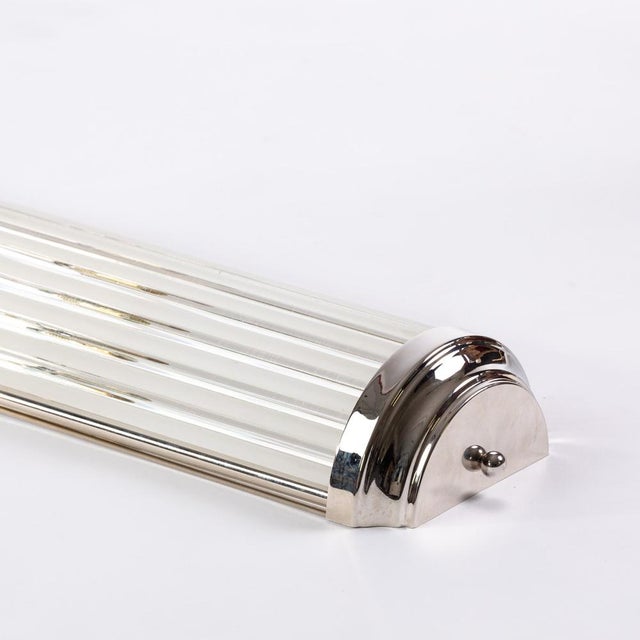 This Art Deco wall lamp combines classic aesthetics with sophisticated lighting. The alternating clear and opal glass rods...