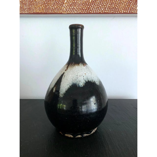 The long neck bottle of classic form was heavily potted with coarse clay with high iron content. The flask, circa 18th...