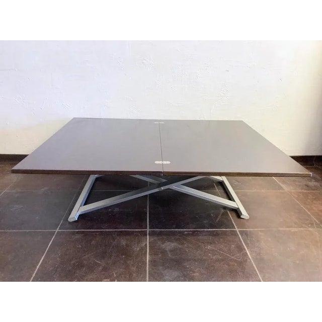 1 coffee table from the 1990s that can be transformed into a dining table by rotating and unfolding the tabletop and using...