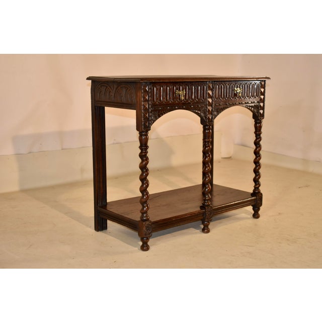 19th century English oak small potbound/console table with lovely hand carved decoration. The top of this piece is made...