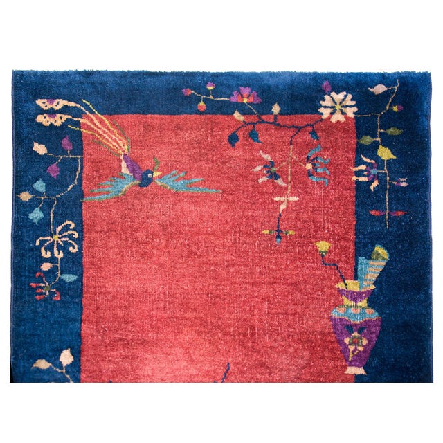 A wonderful early 20th century Chinese Art Deco rug with a cranberry field surrounded by a wide indigo border, and all...