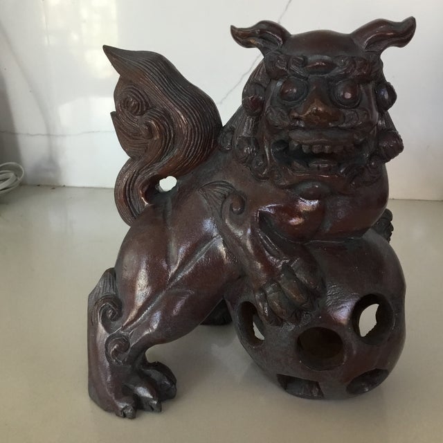 Hand carved wooden pair with beautiful attention to detail. Dogs are perched on a ball that has been carved inwardly while...