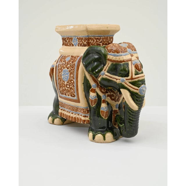 A ceramic decoration from 1960s France in the shape of an elephant. A saddle seat and blanket are glazed with pale blue...