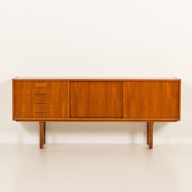 This scandinavian mid-century sideboard comes from the 1960s and is reminiscent of designs by nils jonsson. It combines...
