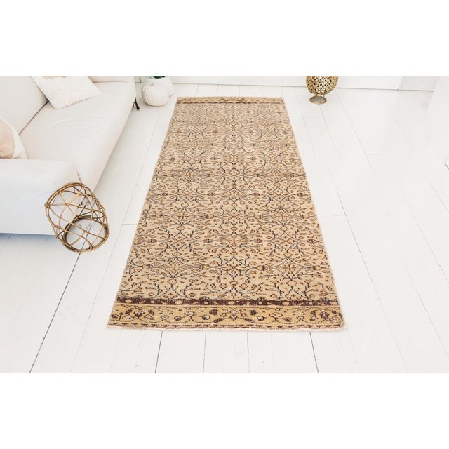 This is a vintage Turkish Oushak rug from the Mid 20th Century. The piece was hand-knotted.