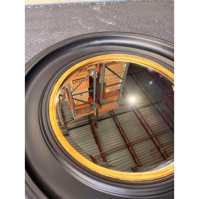 Make a statement with this bold circular mirror, designed in a sleek contemporary style. The wide black frame creates...