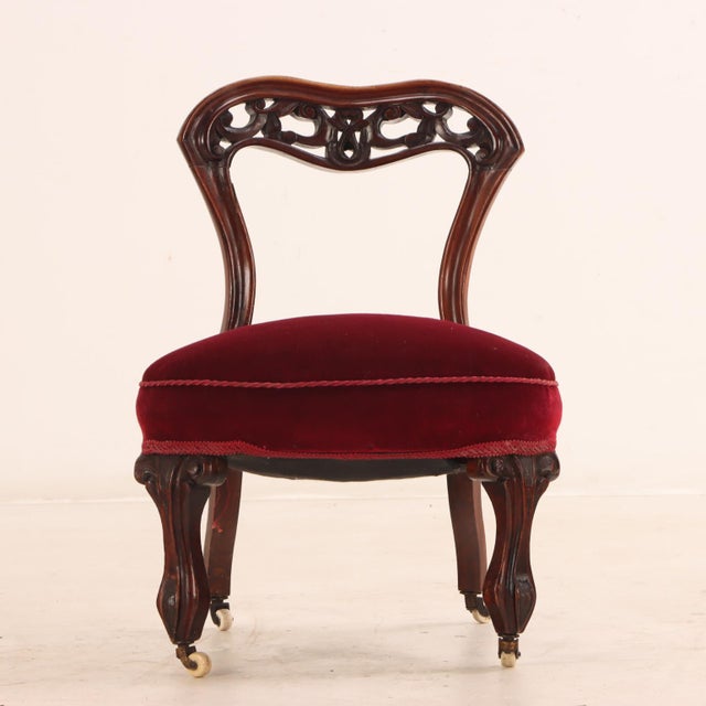 The petite salon or slipper-form accent chair features an elegant open balloon-back silhouette made from solid, richly...