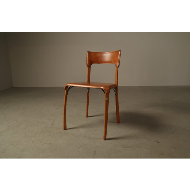 A distinctive set of five Italian dining chairs dating from the 1990s, combining a light-toned wooden frame with cognac...