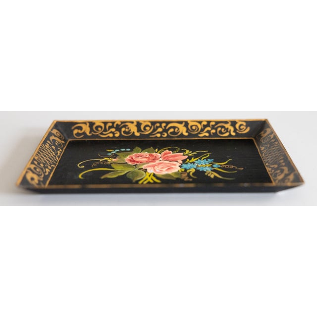 A lovely petite French rectangular black tole dresser tray with a hand painted gilt border and floral design, circa 1950....