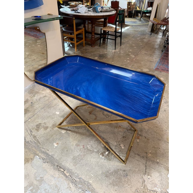 Elegant vintage Italian folding tray table from the 1970s featuring a vibrant cobalt blue enamel tray framed by a polished...