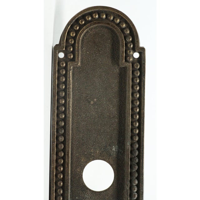 Art Deco style narrow bronze door back plate with a beaded trim. The original mounting screws are not available. Good...