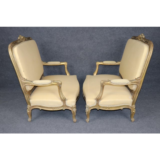 This is a fine Pair of Late 19th-Century French Louis XV Style Gilded Canapés / Marquises Exude palatial grandeur with...