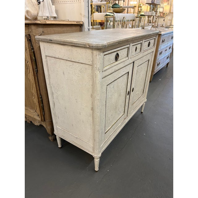 This 19th-century French Louis XVI Painted Server is a captivating antique piece. Adorned with delicate painted details,...