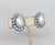 Circa 1953 to 1955 rhodium plated oval faux-pearl with round blue aurora borealis accents surround clip earrings. Marked...