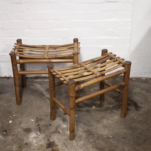 A pair of bamboo stools which feature a slatted bamboo top with decorative woven supports. This piece is attributed to the...
