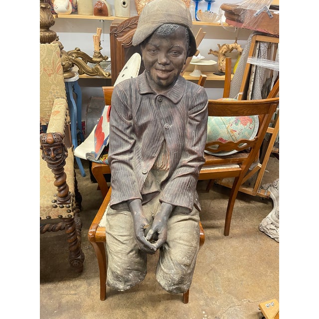 A life-size polychrome terracotta sculpture of a seated young boy., matching late 19th century European works produced or...
