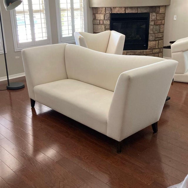 This Shabby Chic loveseat features a clean, cream-colored upholstery and sturdy wooden legs. Its spacious, gently curved...