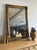 A large 19th century Napoleon III mirror with a richly detailed giltwood frame, featuring deeply carved scrollwork, floral...